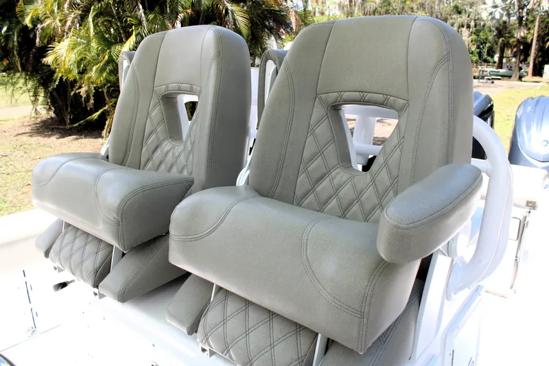 Slide: The Image of 2021 Sportsman Open 282 Center Console boat seats with gray upholstery and diamond stitching. - 17