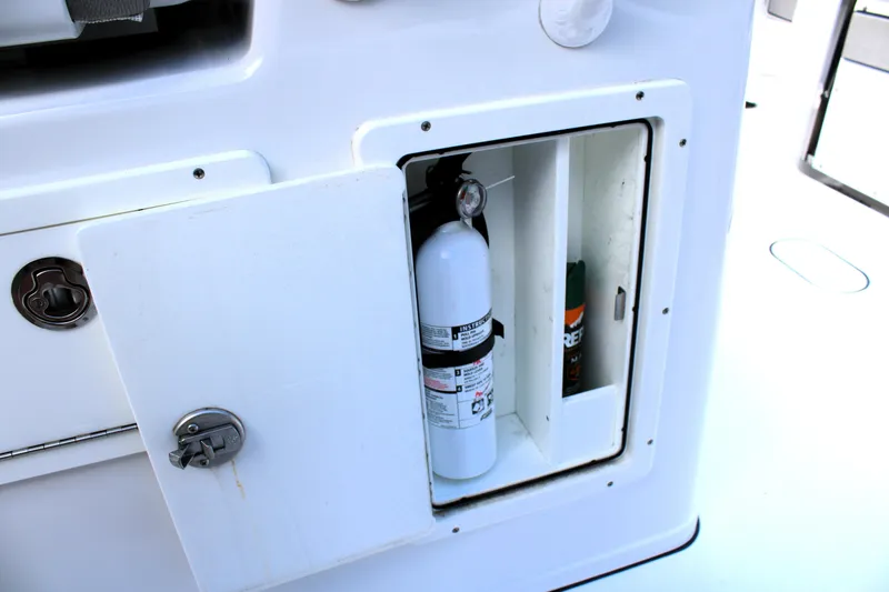 Slide: The Image of Storage compartment on a 2021 Sportsman Open 282 Center Console boat with fire extinguisher. - 25