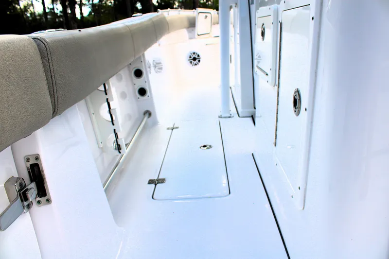 Slide: The Image of 2021 Sportsman Open 282 Center Console boat interior with cushioned seating and storage compartments. - 26