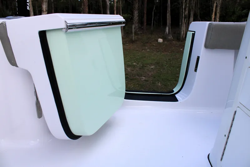 Slide: The Image of 2021 Sportsman Open 282 Center Console boat interior with open hatch, forest background. - 29