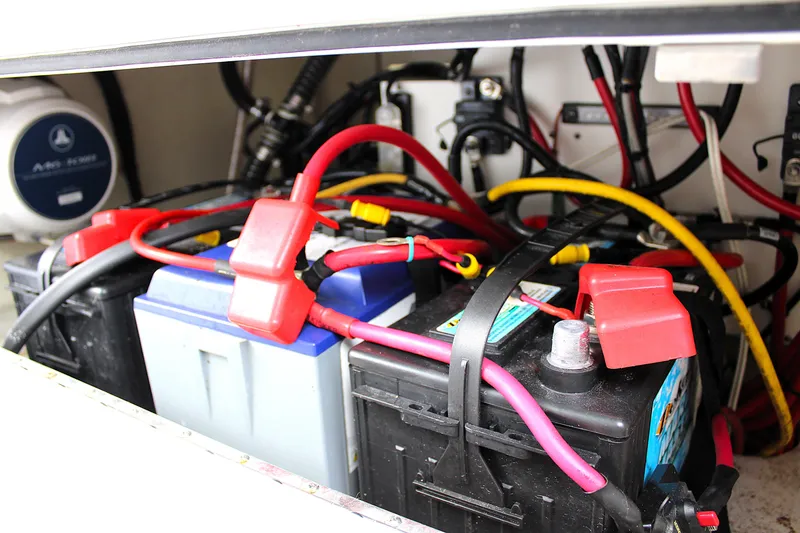 Slide: The Image of 2021 Sportsman Open 282 Center Console battery compartment with cables and connections. - 44