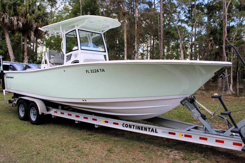 Slide: The Image of 2021 Sportsman Open 282 Center Console boat on trailer in wooded area. - 48