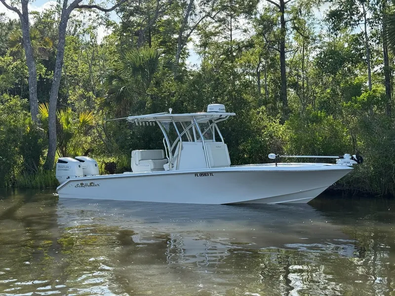 Slide: The Image of 2023 SeaHunter 28 Floridian boat on calm water, surrounded by lush greenery. - 3