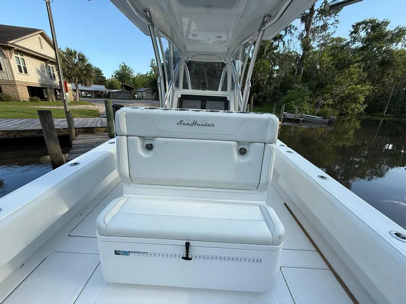 Slide: The Image of 2023 SeaHunter 28 Floridian boat interior with white seating and console, dockside view. - 30