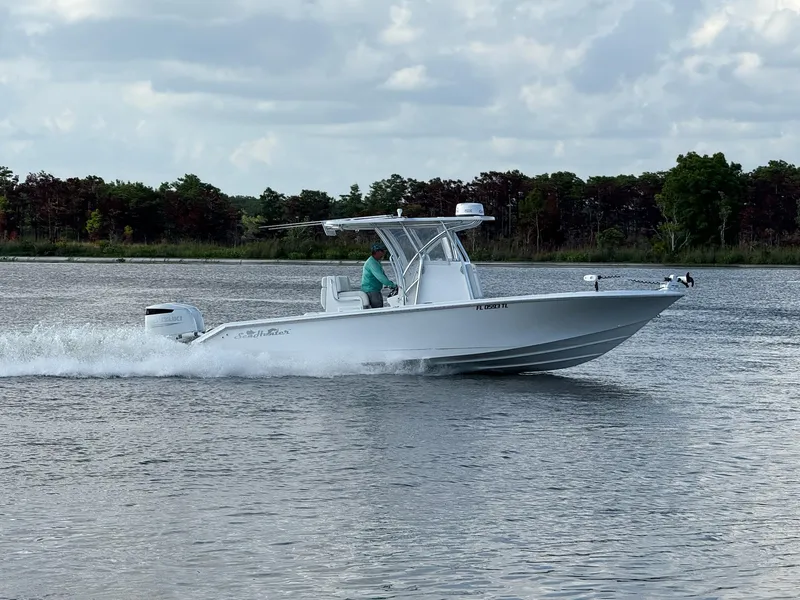 Slide: The Image of 2023 SeaHunter 28 Floridian boat cruising on a calm lake under a cloudy sky. - 4