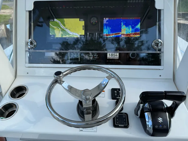 Slide: The Image of 2023 SeaHunter 28 Floridian boat dashboard with steering wheel and navigation screens. - 42