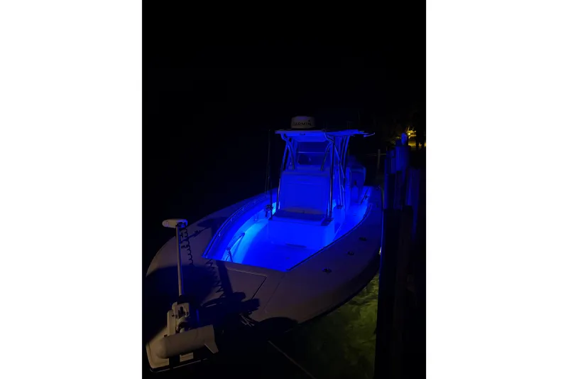Slide: The Image of 2023 SeaHunter 28 Floridian boat illuminated with blue lights at night. - 69