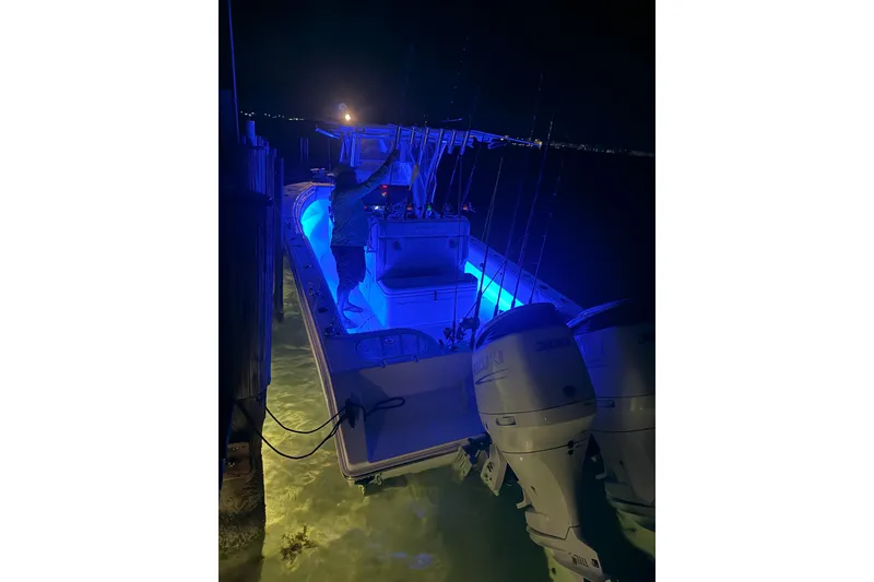 Slide: The Image of 2023 SeaHunter 28 Floridian boat illuminated at night with blue lights. - 70