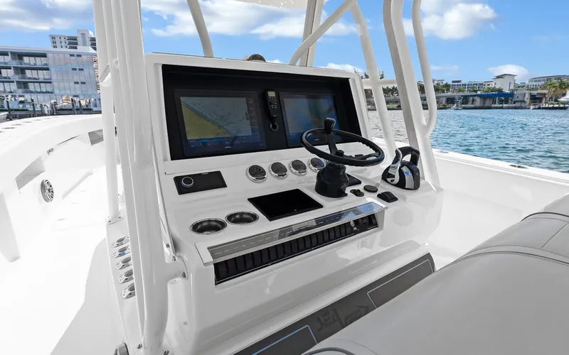 Slide: The Image of 2019 SeaVee 390Z boat console with navigation screens and steering wheel, dockside view. - 20