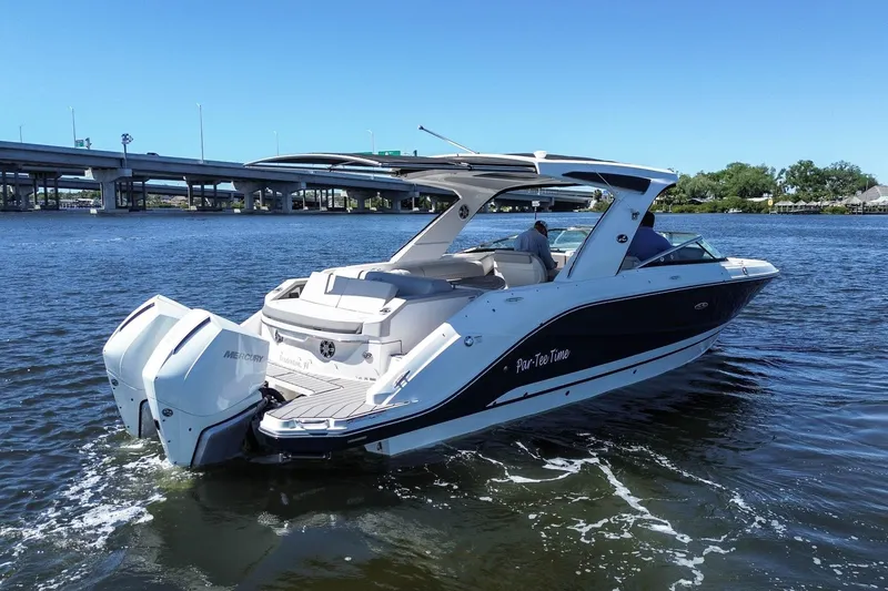 The Image of 2023 Sea Ray SLX 310 Outboard boat cruising on a sunny day near a bridge. - 0