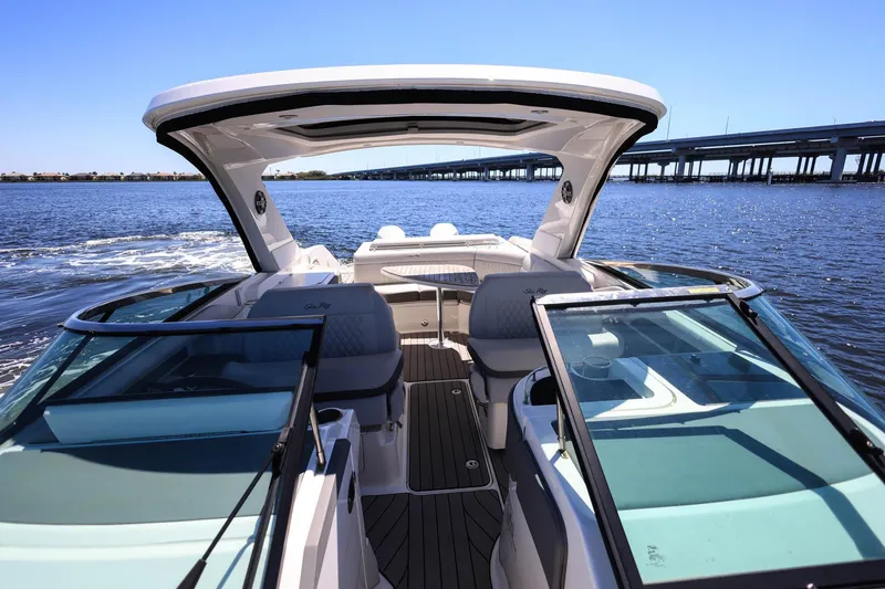 Slide: The Image of 2023 Sea Ray SLX 310 Outboard cruising on open water under a clear blue sky. - 12