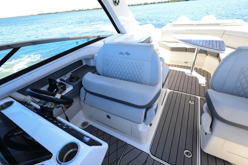 Slide: The Image of 2023 Sea Ray SLX 310 Outboard interior with luxurious seating and sleek design on open water. - 13