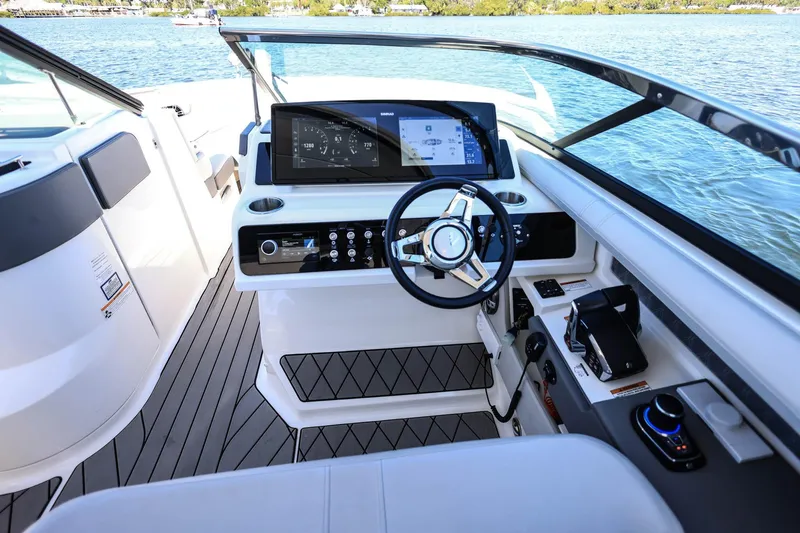 Slide: The Image of 2023 Sea Ray SLX 310 Outboard helm with modern controls and sleek design on the water. - 16