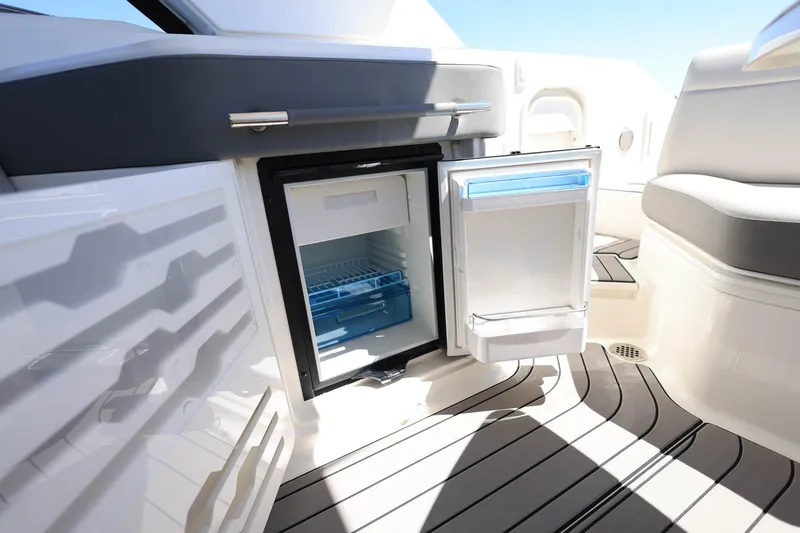 Slide: The Image of 2023 Sea Ray SLX 310 Outboard boat interior with open mini fridge. - 27