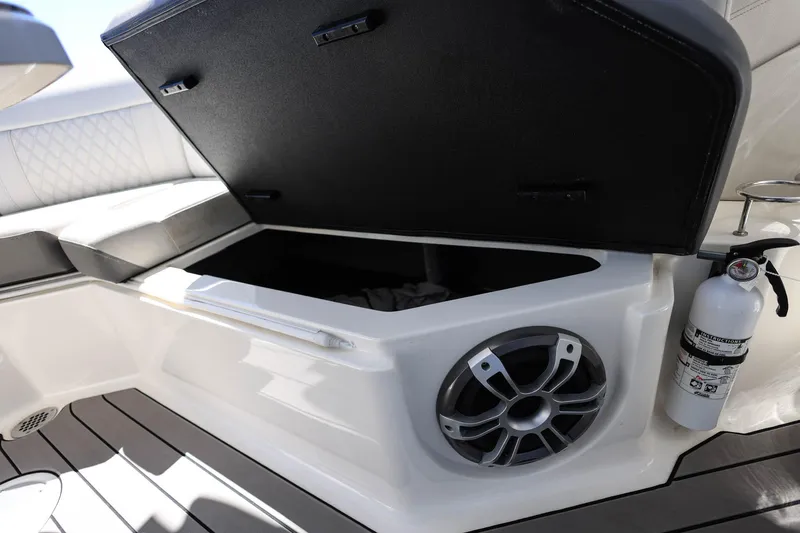 Slide: The Image of 2023 Sea Ray SLX 310 Outboard storage compartment with speaker and fire extinguisher. - 31