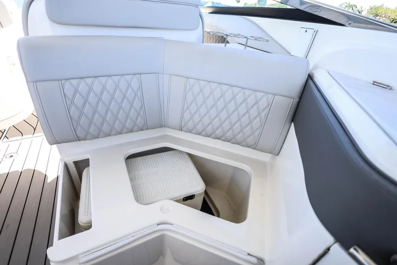 Slide: The Image of 2023 Sea Ray SLX 310 Outboard boat interior with cushioned seating and storage compartment. - 32