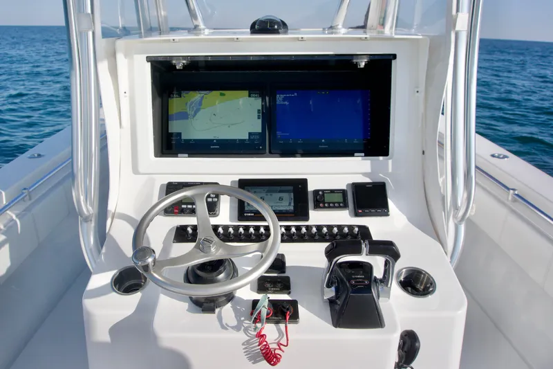 Slide: The Image of Center console of a 2021 Contender 32 ST boat with navigation screens and controls. - 12