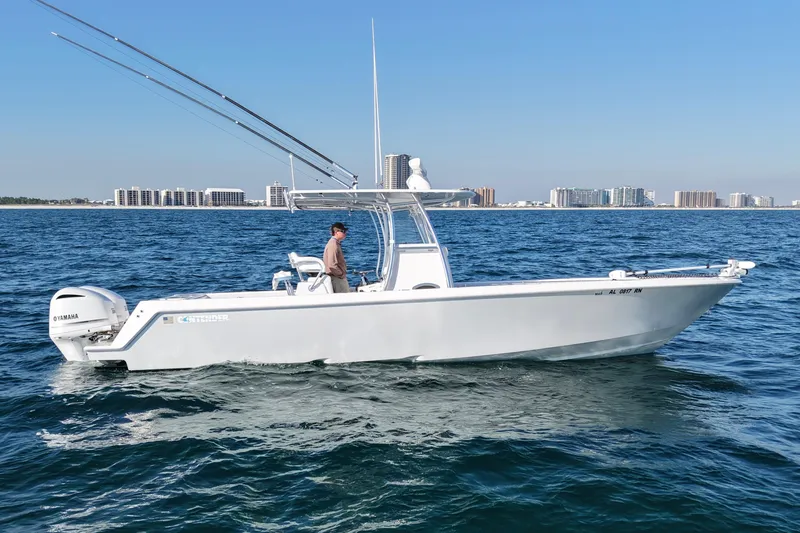 Slide: The Image of 2021 Contender 32 ST boat cruising on open water with city skyline in background. - 3