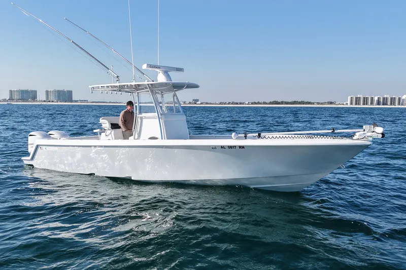 Slide: The Image of 2021 Contender 32 ST boat on open water, clear sky, cityscape in background. - 7
