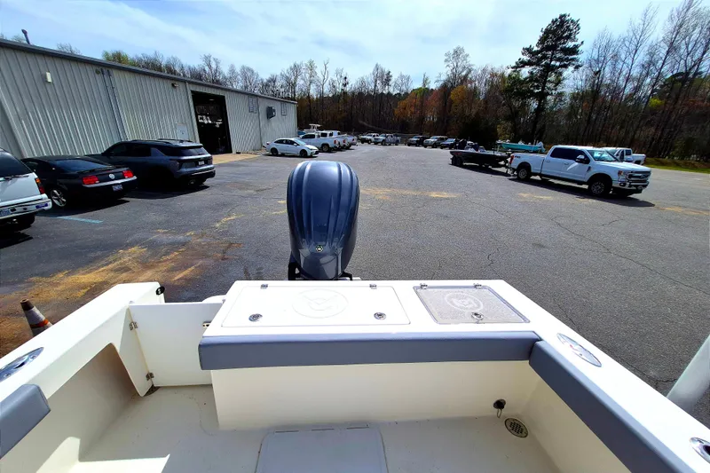 Slide: The Image of 2026 May-Craft 245 Offshore CC boat at a parking lot with vehicles and trees. - 20