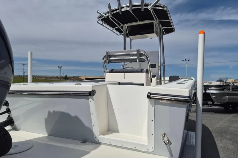 Slide: The Image of 2026 May-Craft 245 Offshore CC boat with center console and T-top under clear sky. - 21