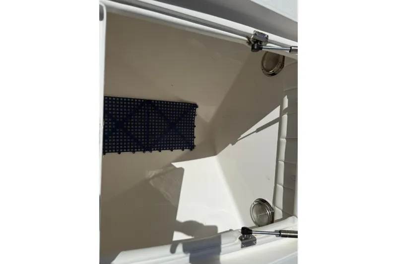 Slide: The Image of Storage compartment of a 2009 Intrepid 323 Open boat, featuring a grid mat. - 10