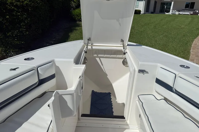 Slide: The Image of 2009 Intrepid 323 Open boat interior with open storage compartment and cushioned seating. - 12