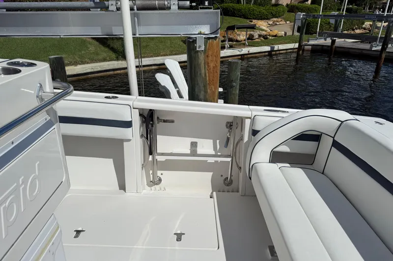 Slide: The Image of 2009 Intrepid 323 Open boat interior with white seating and dock view. - 14