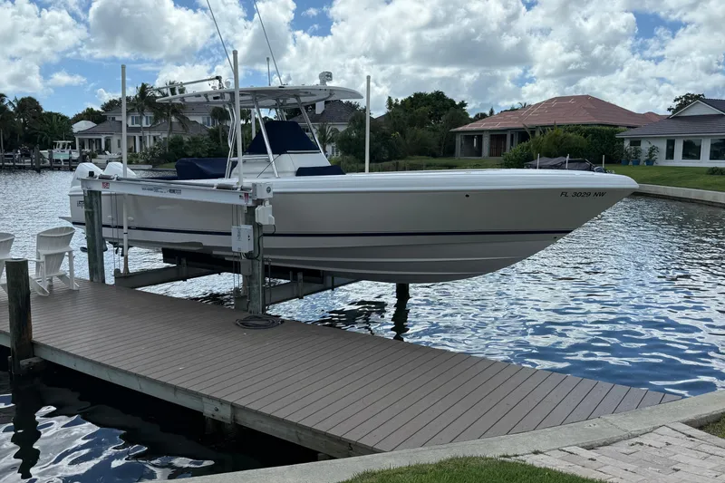 Slide: The Image of 2009 Intrepid 323 Open boat docked on a lift by waterfront homes. - 19