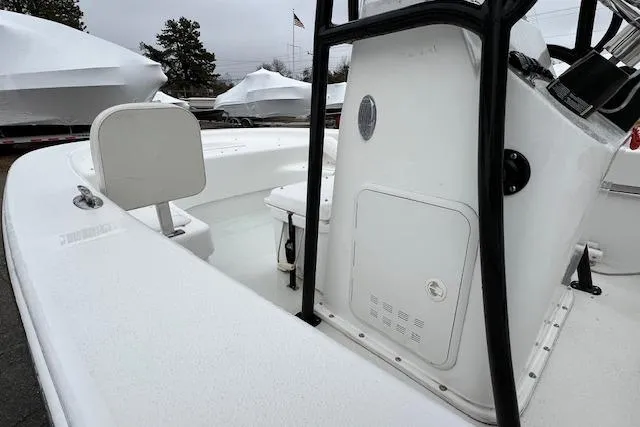 Slide: The Image of 2021 Savannah SS19 boat interior with console and seating, parked outdoors. - 2