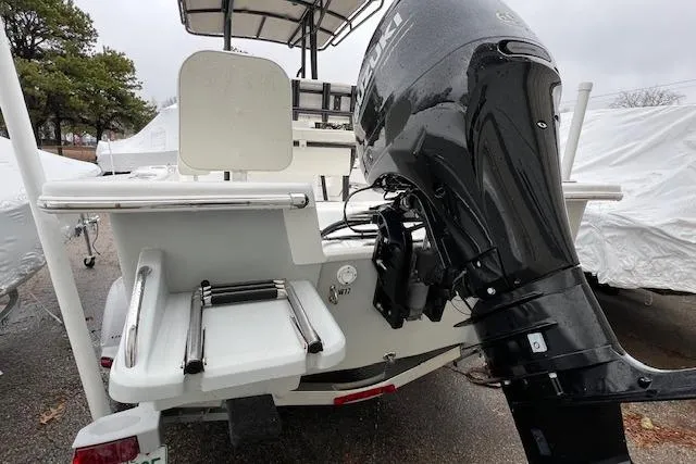 Slide: The Image of 2021 Savannah SS19 boat with outboard motor and swim platform, parked outdoors. - 6