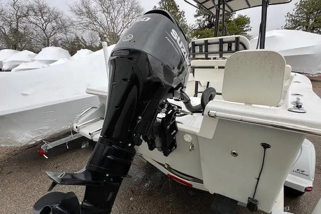 Slide: The Image of 2021 Savannah SS19 boat with Suzuki outboard motor, parked outdoors. - 8
