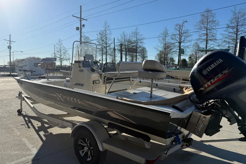 Slide: The Image of 2016 Xpress H20B Bay boat with Yamaha engine on trailer, parked outdoors. - 5