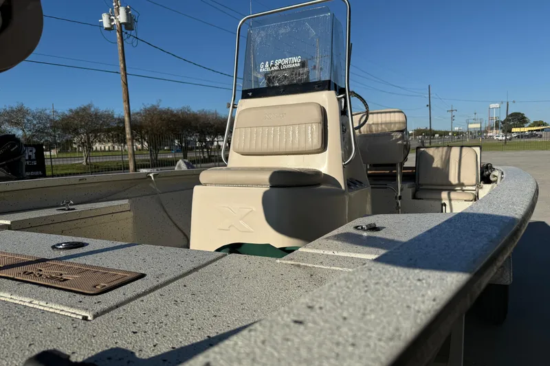 Slide: The Image of 2016 Xpress H20B Bay boat with beige seating, parked outdoors under clear blue sky. - 7