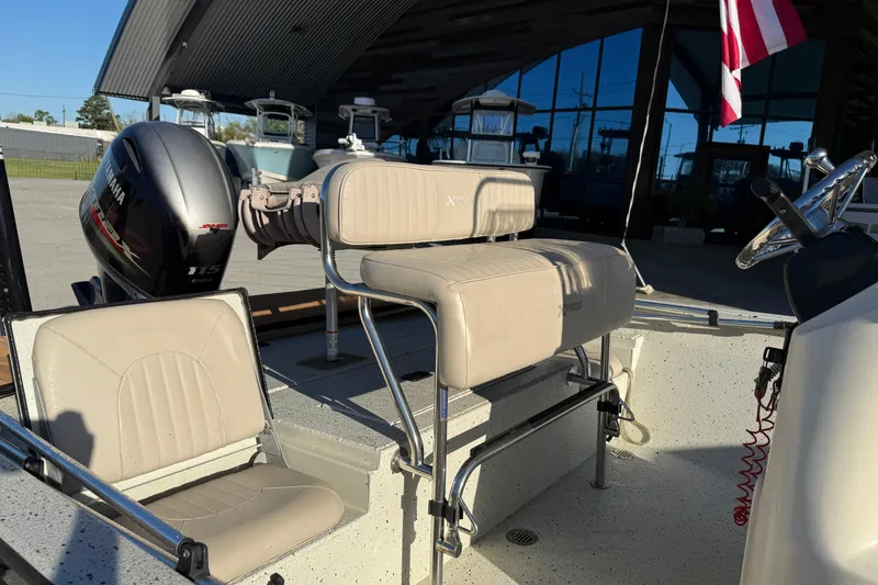 Slide: The Image of 2016 Xpress H20B Bay boat interior with Yamaha 115 engine, featuring beige seating and steering console. - 9