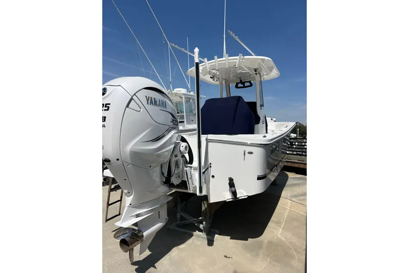 Slide: The Image of 2023 Regulator 26XO boat with Yamaha engine, docked under clear blue sky. - 2