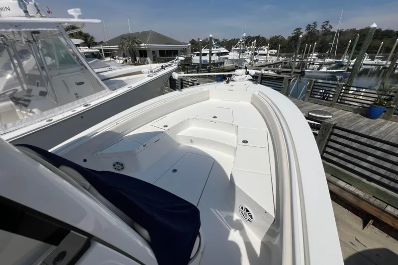 Slide: The Image of 2023 Regulator 26XO boat docked at a marina, showcasing spacious deck and seating. - 6