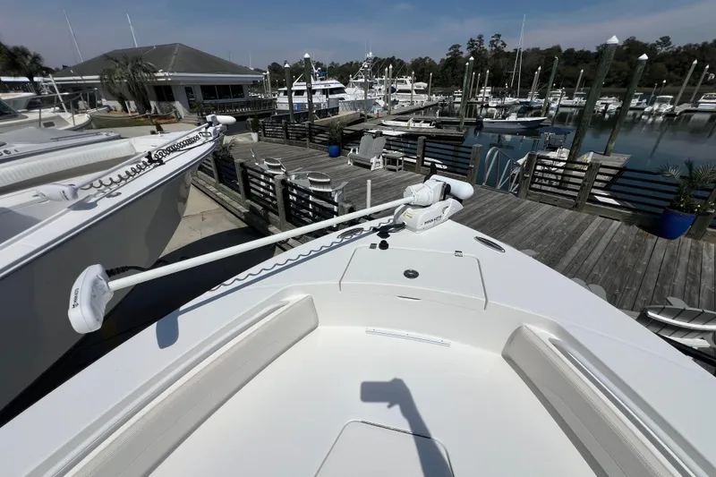 Slide: The Image of 2023 Regulator 26XO boat docked at marina with trolling motor. - 7