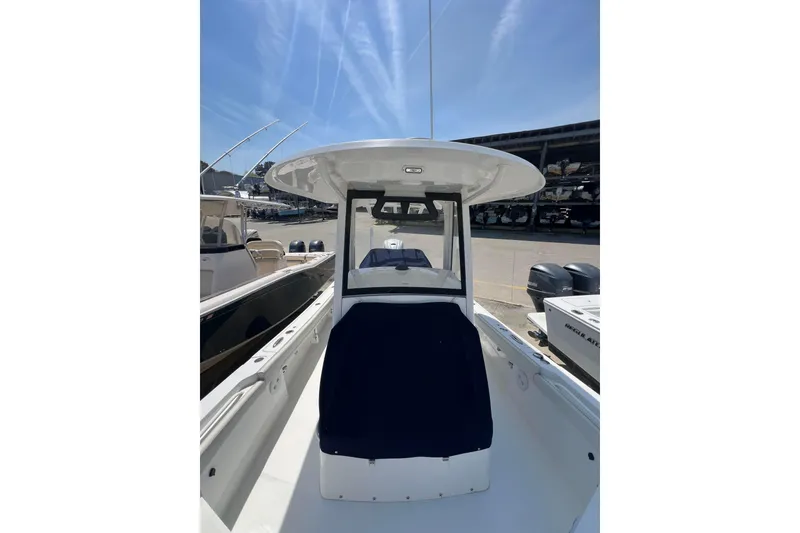 Slide: The Image of 2023 Regulator 26XO boat with T-top, docked under clear blue sky. - 8