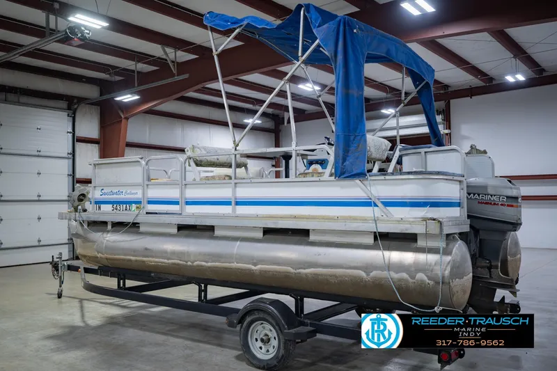 Slide: The Image of 1993 Godfrey SW 180 pontoon boat with blue canopy in indoor storage. - 10