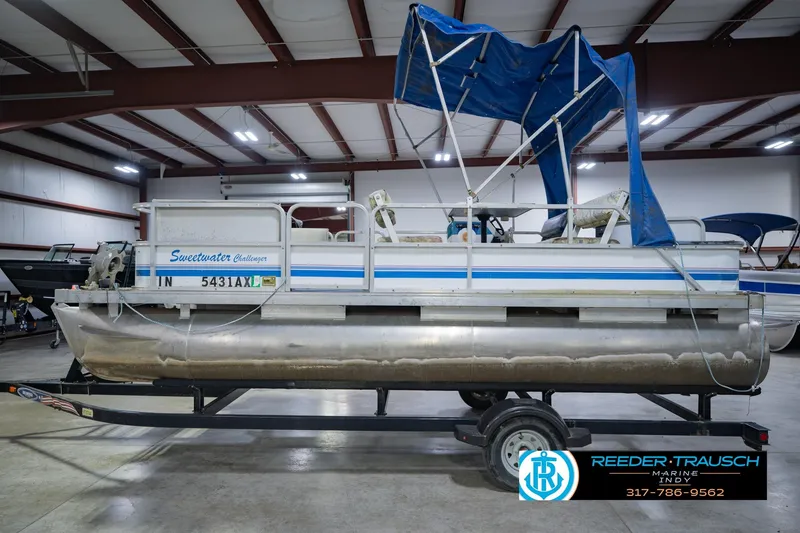 Slide: The Image of 1993 Godfrey SW 180 pontoon boat with blue canopy in indoor storage. - 11