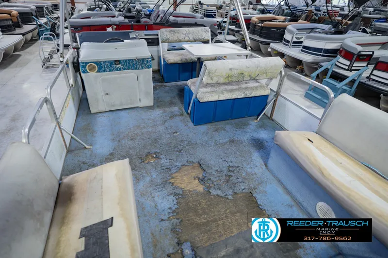 Slide: The Image of 1993 Godfrey SW 180 boat interior with worn seating and flooring in a showroom. - 13