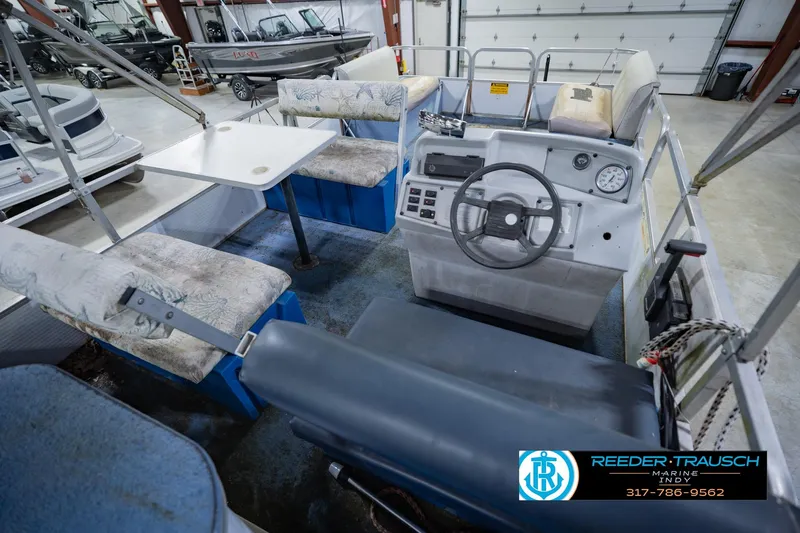 Slide: The Image of 1993 Godfrey SW 180 boat interior with steering console and seating in showroom. - 14