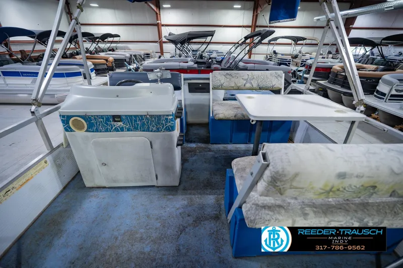 Slide: The Image of Interior of a 1993 Godfrey SW 180 boat with seating and table in a showroom. - 17