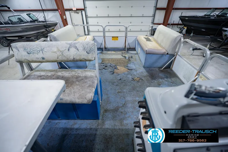 Slide: The Image of Interior of a 1993 Godfrey SW 180 boat with worn seating and flooring in a garage. - 20
