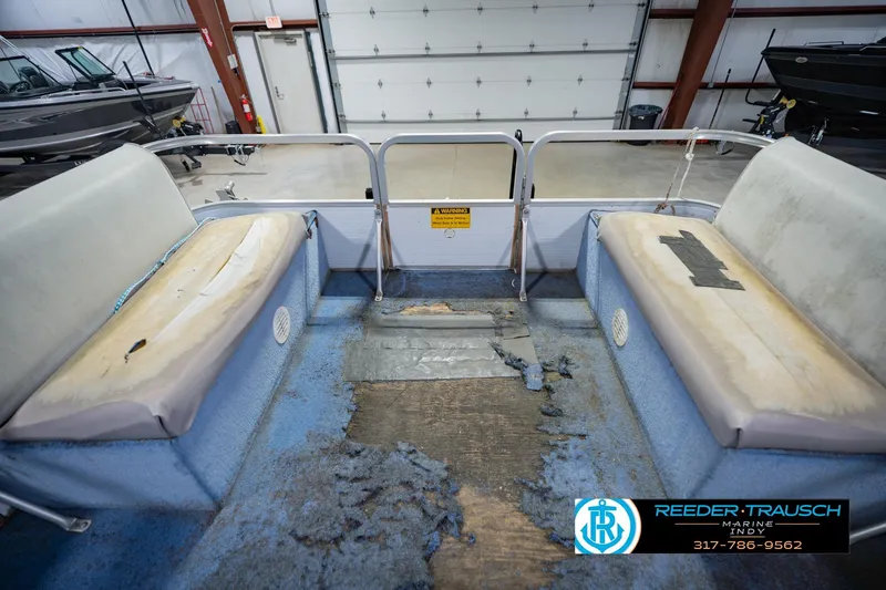 Slide: The Image of 1993 Godfrey SW 180 boat interior with worn seating and flooring in a garage setting. - 21