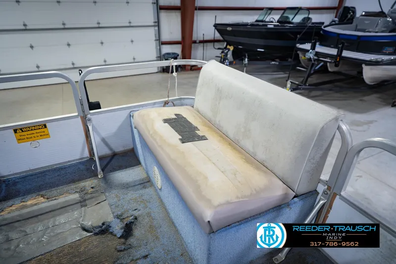 Slide: The Image of 1993 Godfrey SW 180 boat interior with worn seating and visible warning sign. - 22