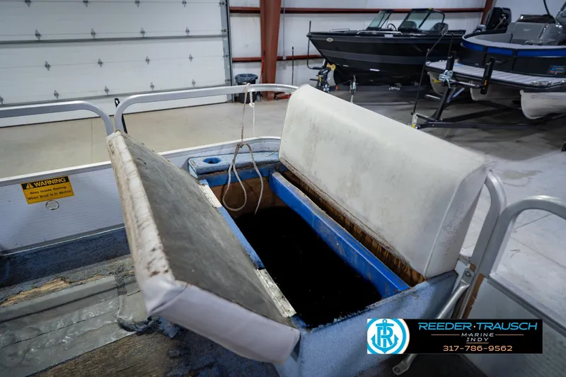 Slide: The Image of 1993 Godfrey SW 180 boat interior with open storage compartment in a showroom. - 23