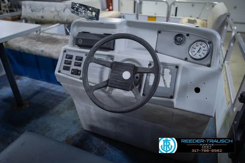 Slide: The Image of 1993 Godfrey SW 180 boat dashboard with steering wheel and gauges, Reeder Trausch Marine logo visible. - 26