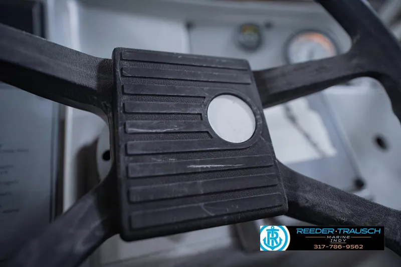 Slide: The Image of Steering wheel of a 1993 Godfrey SW 180 boat, featuring control panel details. - 28